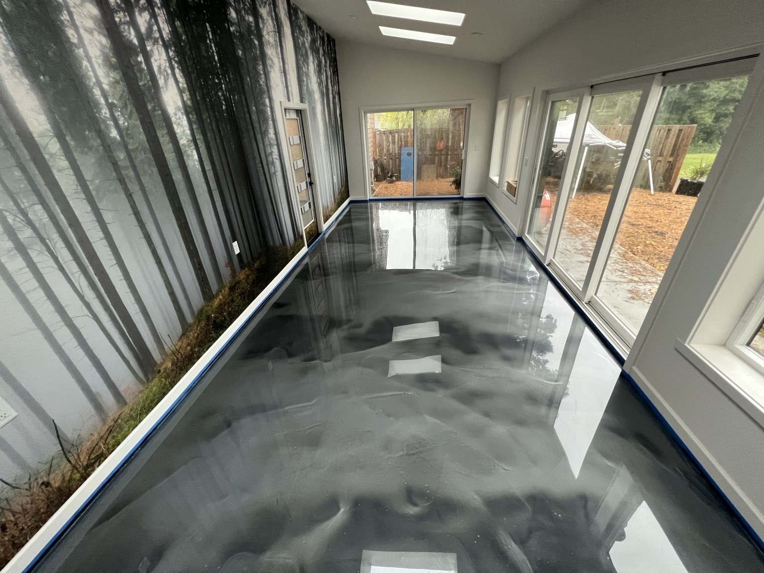 Silver metallic epoxy floor with flowing charcoal patterns